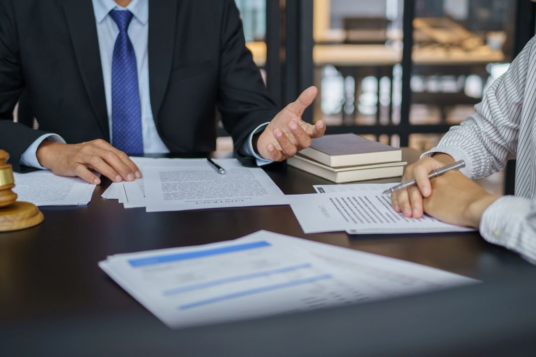 Legal professionals discussing a contract across a desk